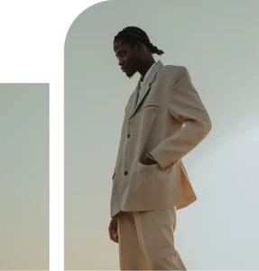 African man in professional clothing stands outdoors against a New York City skyline, appearing thoughtful and composed