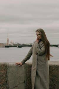 Woman standing near the sea, in a contemplative posture as she gazes toward the horizon