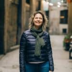Woman walking down a city street, looking upward with ease after a depression therapist in Manhattan, New York.