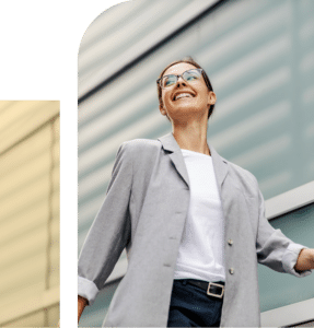 Professional woman in a blazer walking confidently near buildings, representing stability, growth, and self-trust