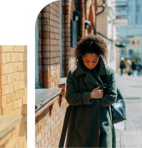 African American woman walking outside looking down thoughtfully, reflecting stress, overwhelm, and inner processing
