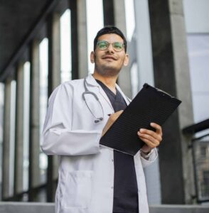 Man doctor signing document in lab coat, therapy for healthcare professionals in Manhattan NYC supporting growth