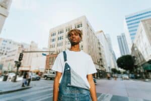 African American man standing before a cityscape, reflecting contemplation, strength, and emotional awareness