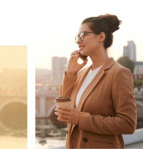 Woman on phone with coffee overlooking city, representing connection, routine, and balanced daily functioning