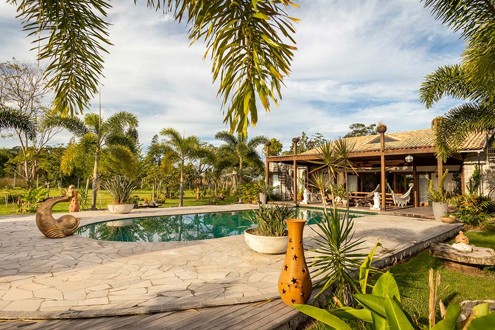 a house with a pool surrounded by palm trees