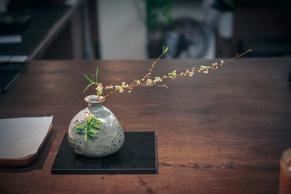small vase with branches on a wooden table